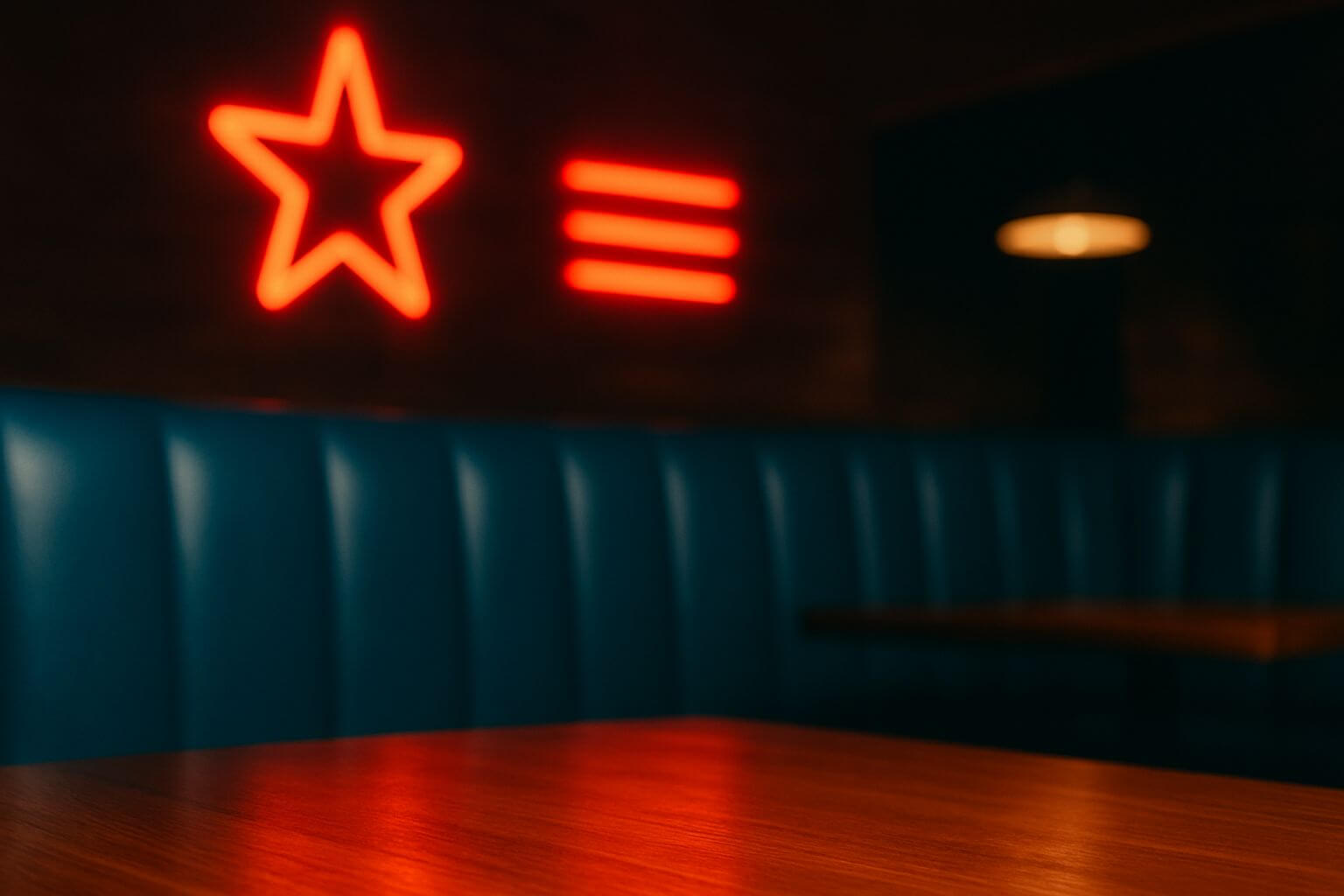 Intérieur du American Pub à Sion avec banquettes bleues et néons rouges en forme d’étoile, ambiance américaine pour déguster burgers et cocktails