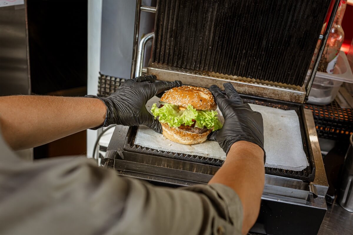 Burger en préparation au American Pub à Sion, restaurant de burgers et ambiance américaine