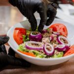Préparation d’une salade fraîche au American Pub à Sion, alternative légère aux burgers dans une ambiance américaine