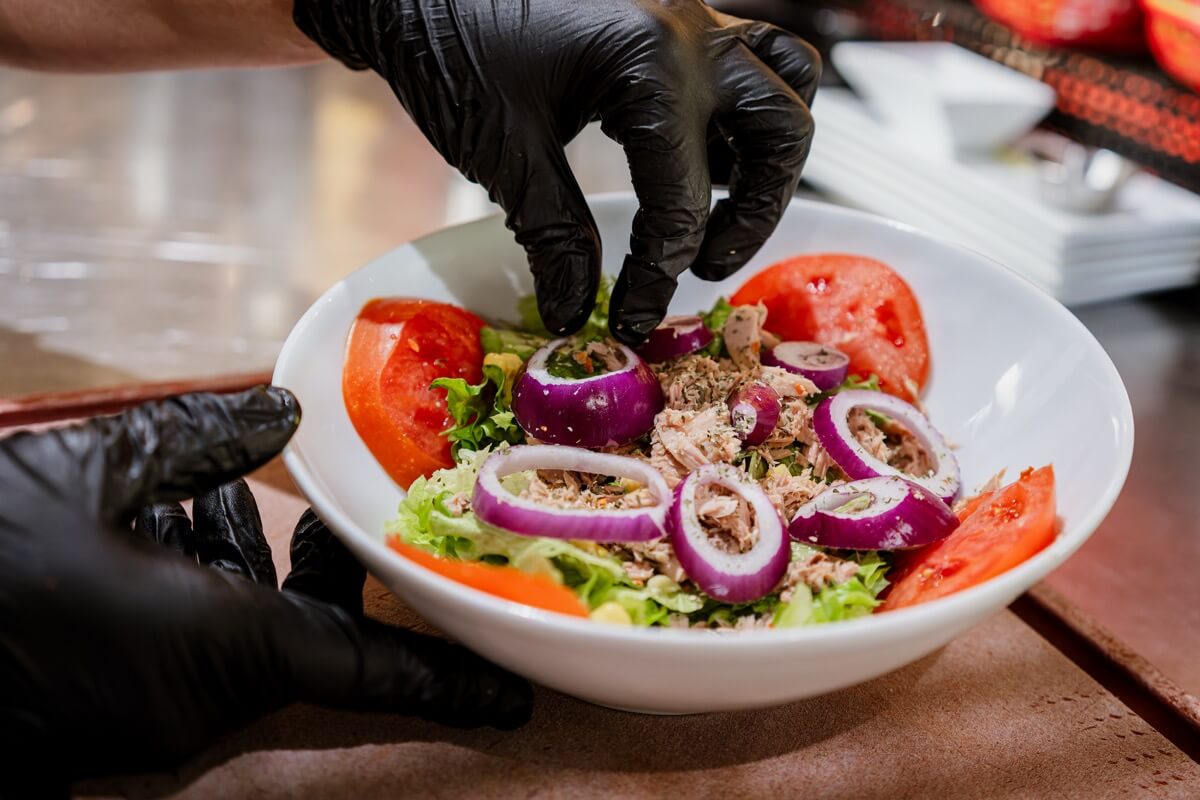 Préparation d’une salade fraîche au American Pub à Sion, alternative légère aux burgers dans une ambiance américaine