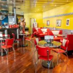 Salle du American Pub à Sion avec banquettes rouges rétro, ambiance diner américain et restaurant de burgers