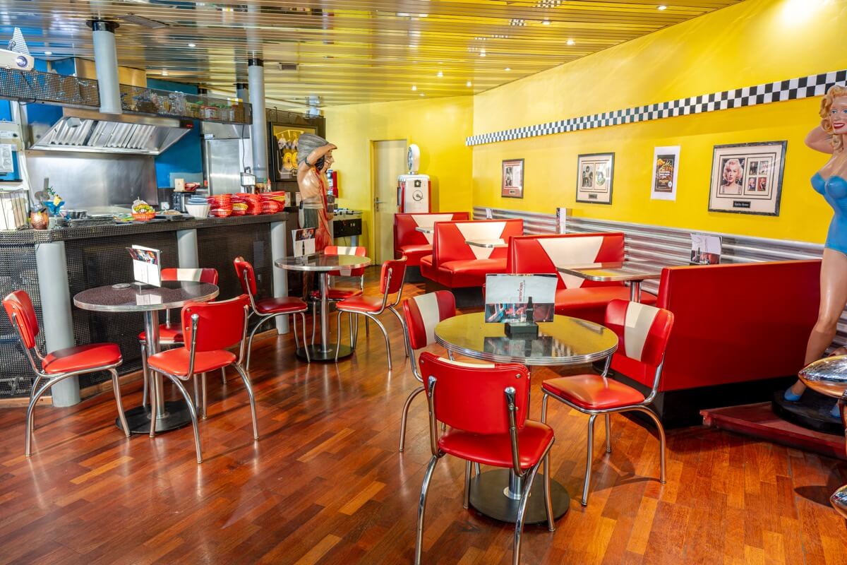 Salle du American Pub à Sion avec banquettes rouges rétro, ambiance diner américain et restaurant de burgers